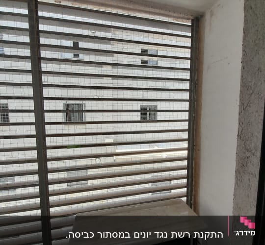 רשת מתכת על חלון למניעת כניסת יונים